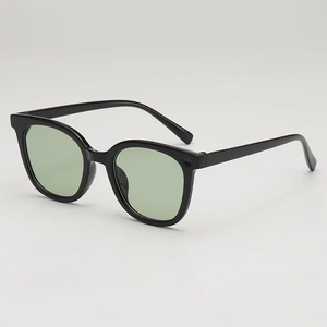 Modern square black frame sunglasses with light green ocean lenses in a 45-degree side view