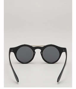 Détail de lunettes de soleil rondes vintage avec monture noire épaisse et double pont en métal