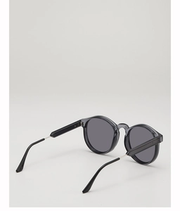 Seitenansicht der runden Retro-Sonnenbrille in Transparentgrau mit schwarzen Bügeln