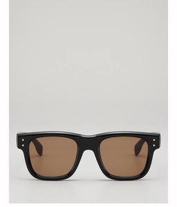 Close-up of black retro square sunglasses with brown lenses and star rivet accents