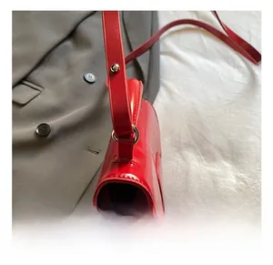 Detail shot of the red oil wax leather handbag showing silver buckle and side stitching