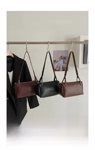 Three elegant vintage pillow bags in burgundy, black and brown leather on display