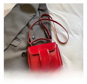Macro shot of bright red patent leather handbag with buckle detail and handle
