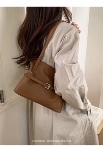 Detalle del bolso tote retro de cuero marrón oscuro con hebilla plateada al hombro