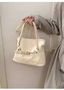 Detalle del bolso tote plisado blanco crema con hebillas finas y correas dobles delgadas