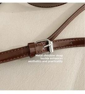 Détail de la bandoulière réglable en cuir marron avec boucle en métal argenté du sac
