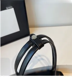 Detail of sturdy double handles on black PU handbag with silver metal fastener hardware