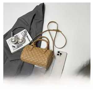 Flat lay of khaki quilted Boston bag with gold hardware and shoulder strap accessories