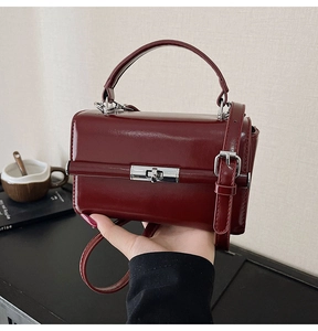 Détail du sac à main en cuir verni bordeaux avec fermoir argenté et bandoulière