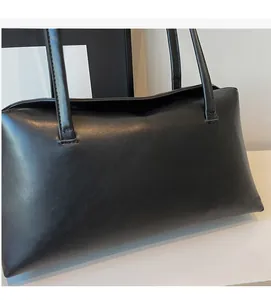 Detail of soft black PU leather shoulder bag featuring minimalist rectangular design