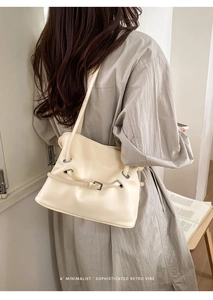 Detalle del bolso tote crema con hebilla metálica y textura de cuero de estilo minimalista