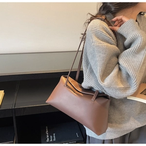 Close-up of minimalist brown rectangular PU leather underarm bag with double slim straps