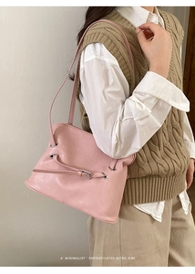 Detalle del bolso de hombro plisado rosa con hebilla plateada retro sobre un modelo
