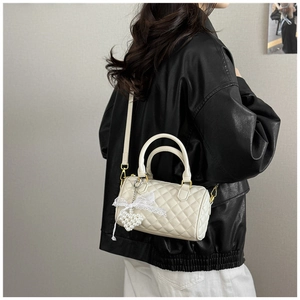 Quilted off-white Boston bag with lace bow and pearl heart charm detail on strap