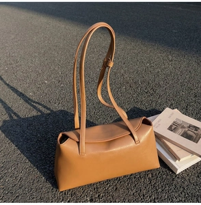 Detailed view of the tan synthetic leather texture and slim strap of the minimal shoulder bag