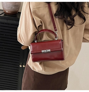 Détail d'un sac à main vintage rouge foncé en cuir PU avec fermoir rotatif argenté