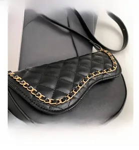Detail shot of black saddle bag with quilted rhombus pattern and chain edge trim