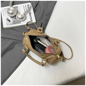 Interior view showing the large capacity of a quilted beige Boston handbag with essentials