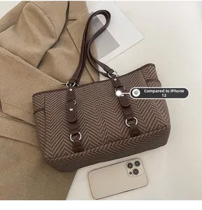 Brown herringbone tote bag size comparison with iPhone 12 showing large capacity