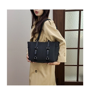 Detail of chevron stitched black tote bag with silver metal rings and rivets