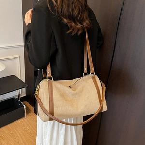Detail of suede beige tote bag featuring contrast leather straps and a spacious boston shape