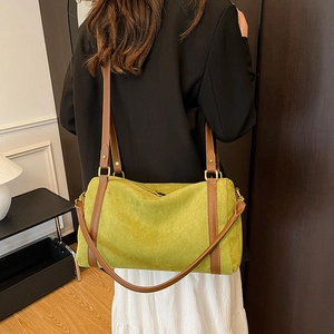 Back view of model wearing a large green suede tote bag with brown leather shoulder straps