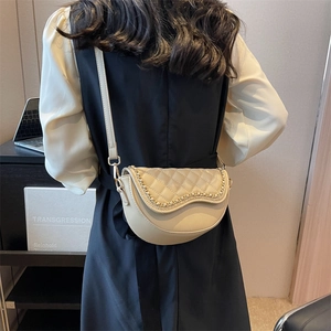 Beige quilted saddle bag with gold chain trim and adjustable strap for women