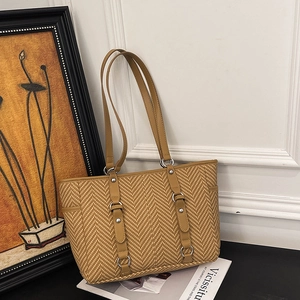 Classic khaki woven tote bag with leather straps and silver buckles in a retro setting