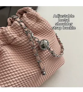 Detail of adjustable silver spherical buckle on woven leather pink chain shoulder bag