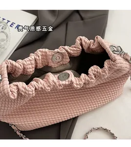Detail of pink woven crossbody bag with magnetic clasp and silver chain strap