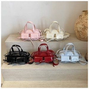 Multiple colors of fashionable minimalist tote bags with ribbon knots on stone stairs