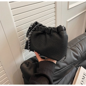 Detail of black cloud woven bag featuring silver chain and textured pleat craftsmanship