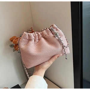 Detailed close-up of pink woven texture bag with silver chain and decorative metal ball