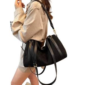 Large black suede tote bag with adjustable shoulder strap and gold buckle for women