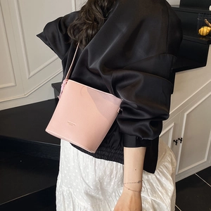 Detail of pink bucket bag made of pebble grain leather with slim shoulder strap