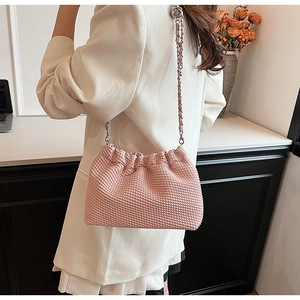 Detailed macro view of pink pleated texture and metal chain strap on small crossbody bag