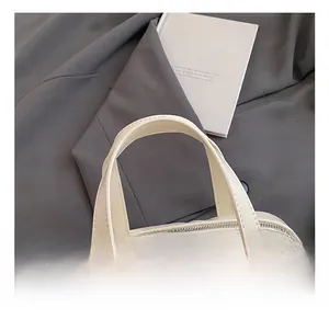 Detail of cream leather handle and stitching on a minimalist crossbody bag