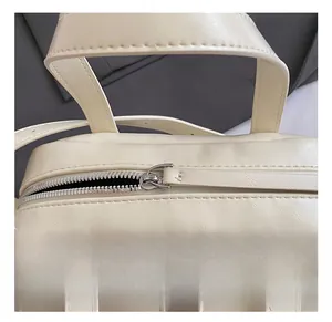 Detailed macro shot of the high-quality silver metal zipper on a cream leather handbag