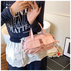 Close-up of pink patent leather handbag with bow detail and double pockets