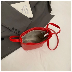 Detail view of red lychee pattern bucket bag with interior zip pocket and lining