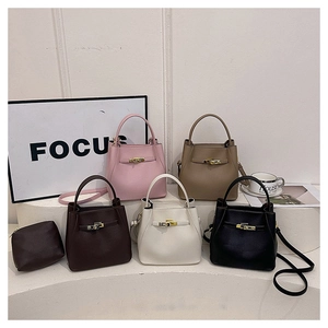 Detail view of five pebbled leather bucket bags with metal turn-lock closure in various colors