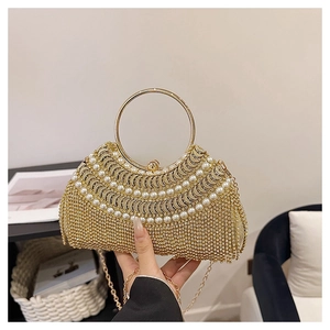 Detailed shot of golden evening bag with sparkling crystals and three layers of white pearls