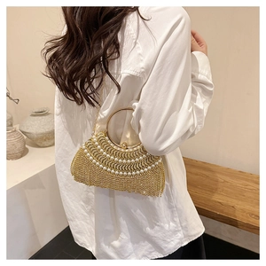 Detail of luxury evening clutch with white pearls and sparkling rhinestone tassels