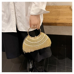 Detail of evening clutch bag featuring white pearls, rhinestone tassels, and gold ring handle