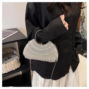 Detail of silver evening clutch with pearl inlay and dangling rhinestone fringe accents