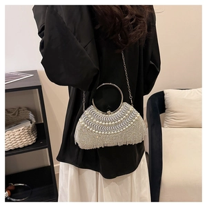Close-up of vintage evening clutch bag featuring elegant pearl inlay and rhinestone tassels