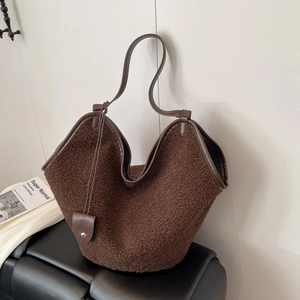 Detail of brown faux fur tote bag with dark leather trim and slender shoulder straps