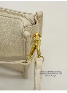 Detail view of lychee-grain leather bag with custom gold hardware and detachable strap