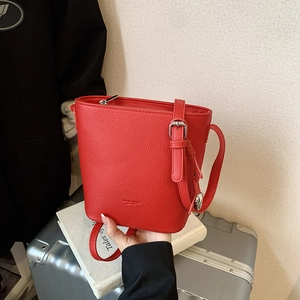 Fashionable red lychee leather bucket bag with silver hardware and adjustable strap
