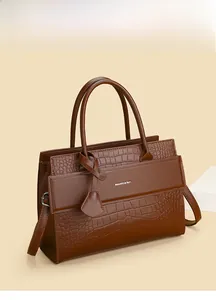 Close-up of brown faux crocodile leather tote bag with silver logo and dual handles